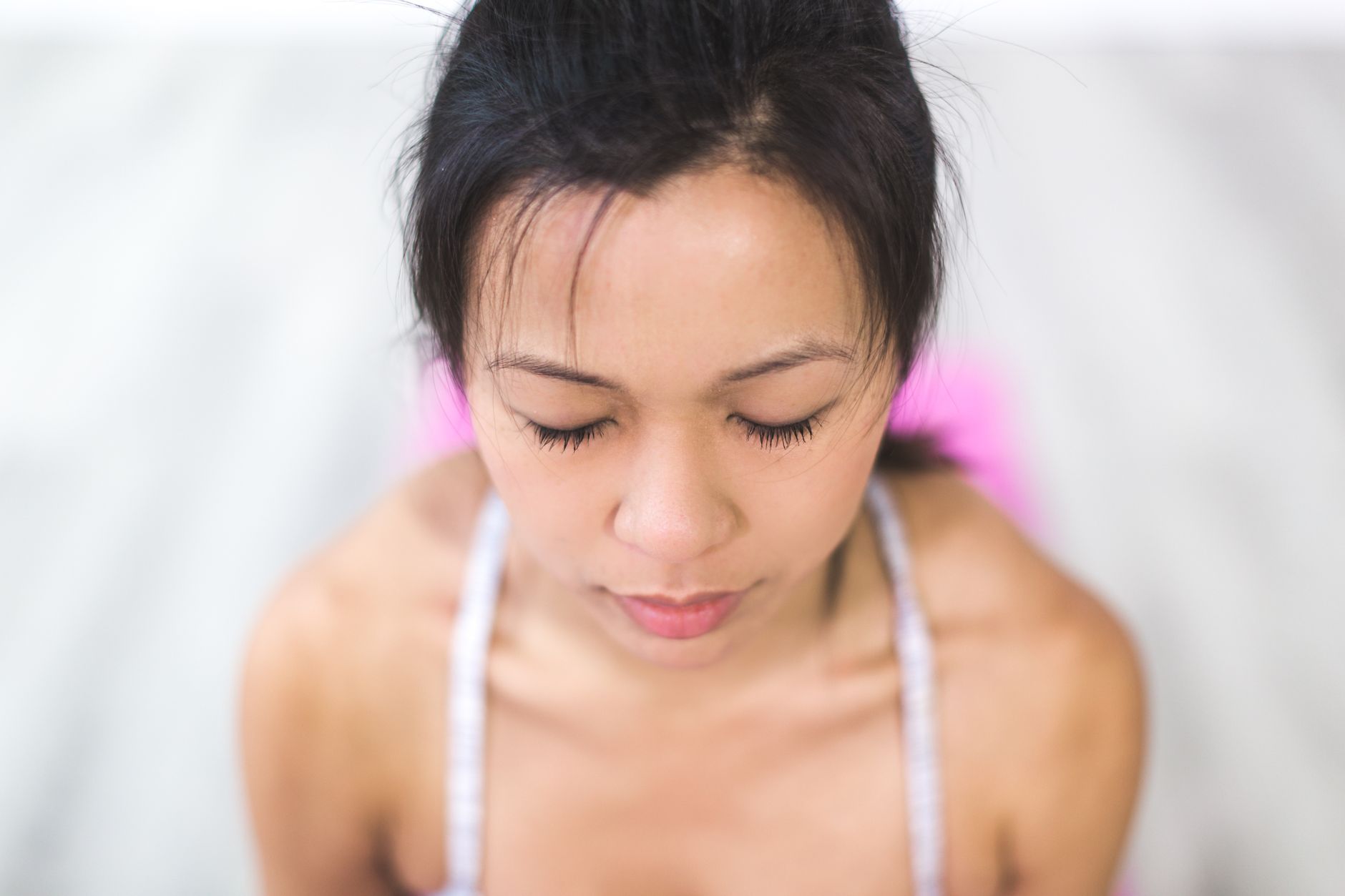 室内で目を閉じて静かに瞑想する女性の姿